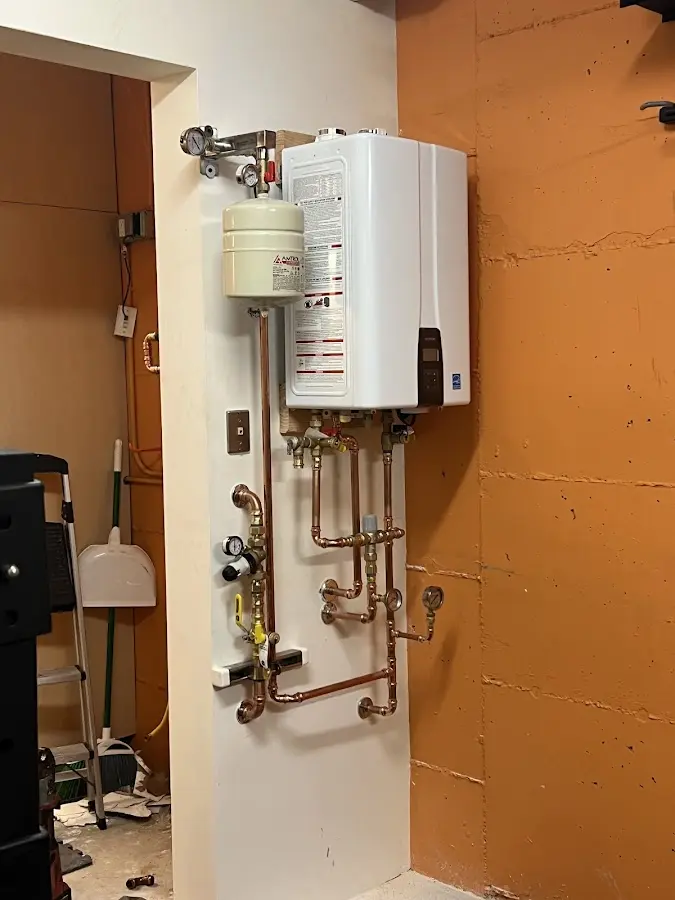 Plumbing technician inspecting water heater connections in Conover